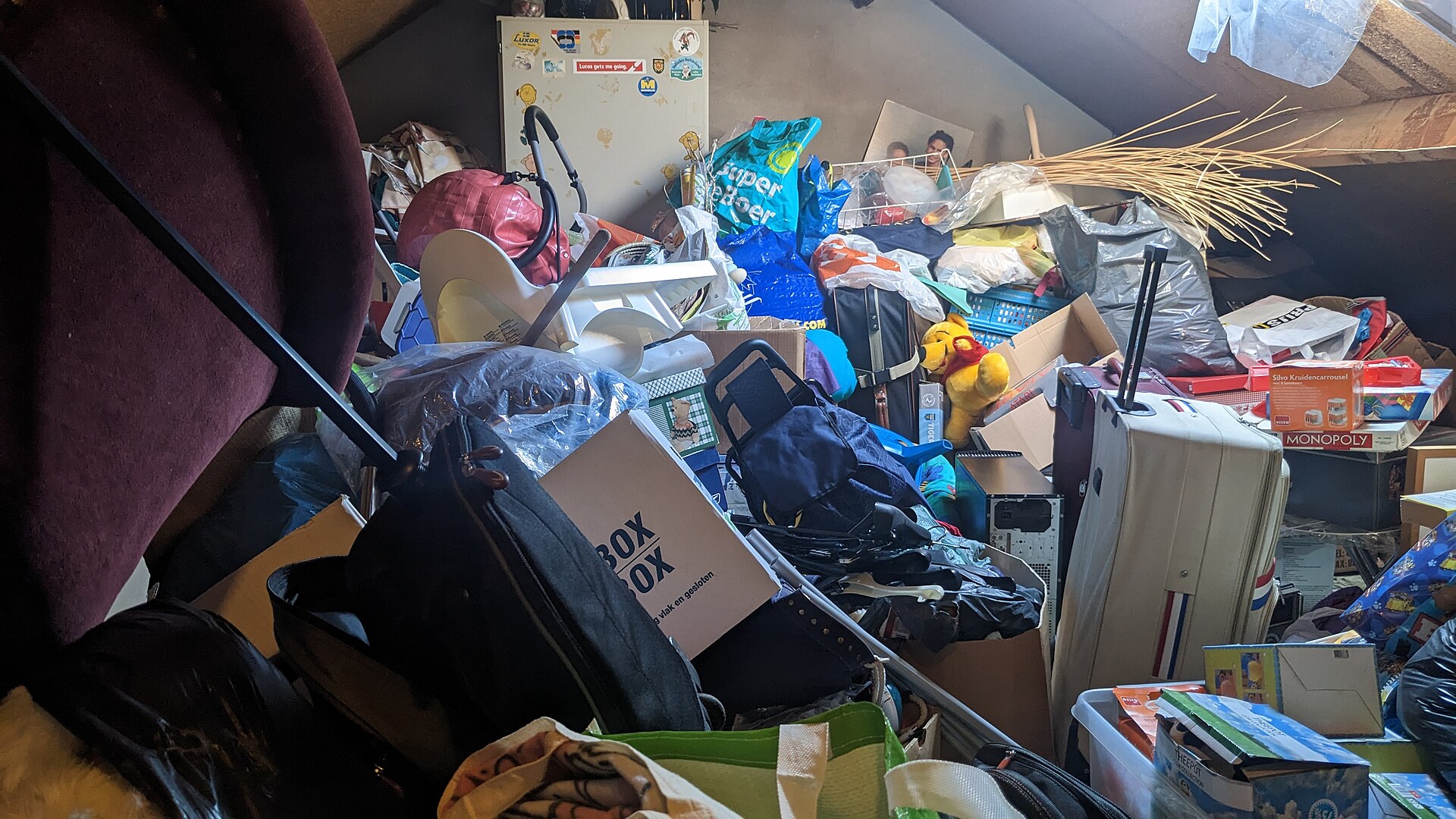 Vollgestellter Dachboden mit Kisten, Koffern und Hausrat vor der Entrümpelung