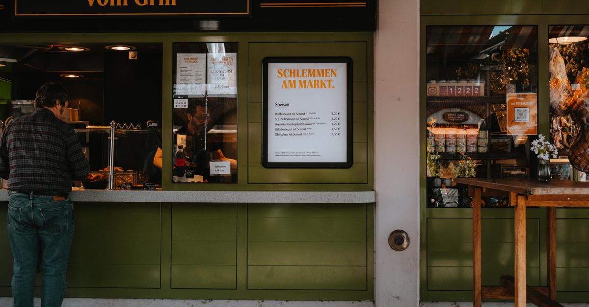 Frankfurter Imbissstand „Schlemmen am Markt" mit Speisekarte – Sinnbild für die internationale Esskultur der Stadt