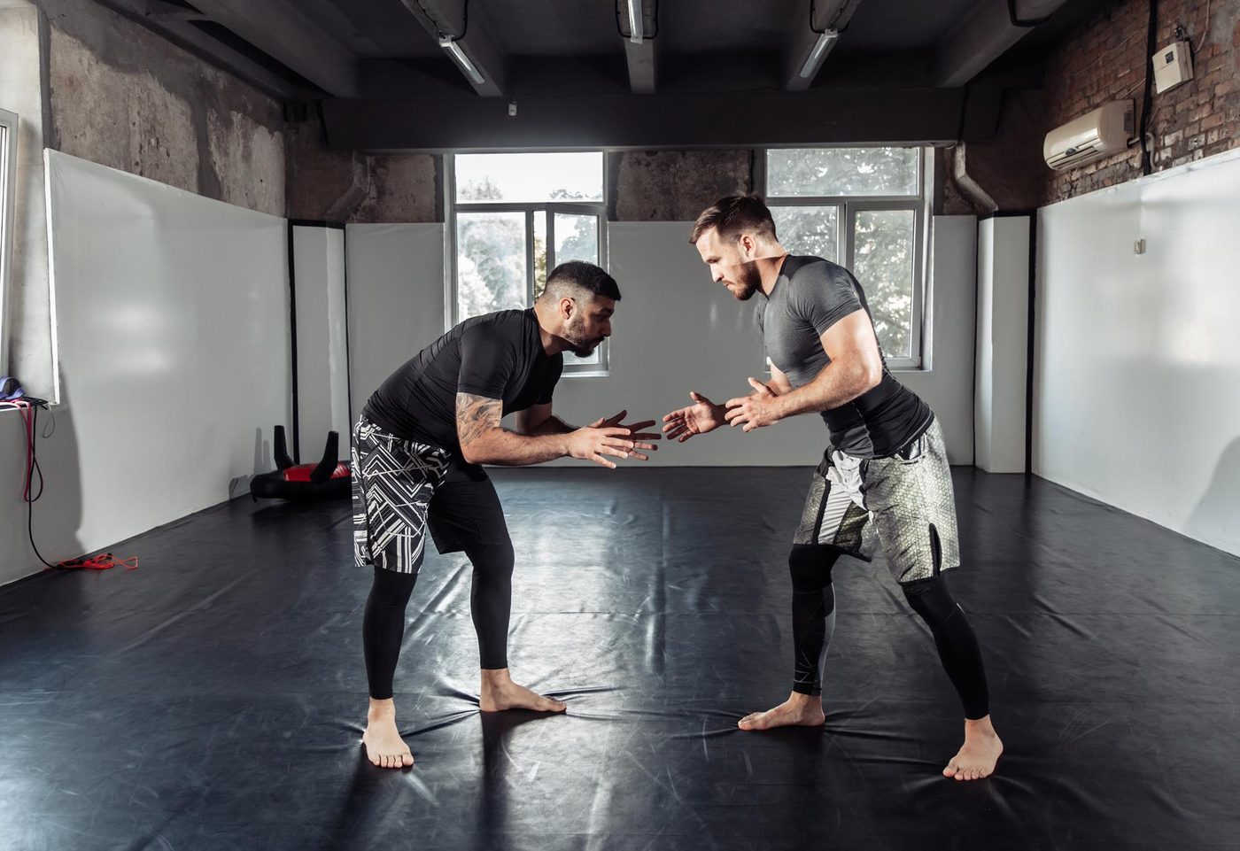 Zwei Kampfsportler trainieren Stand- und Bodenkampf-Techniken im Sparring