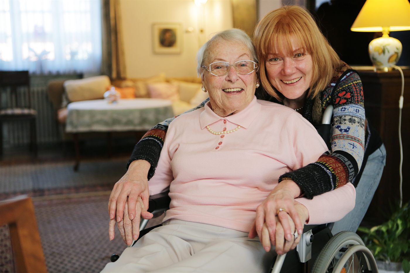 Seniorin im Rollstuhl wird zu Hause von einer Angehörigen oder Betreuungskraft begleitet – Seniorenbetreuung in Frankfurt gibt Sicherheit im Alltag nach Reha oder Krankenhausaufenthalt.