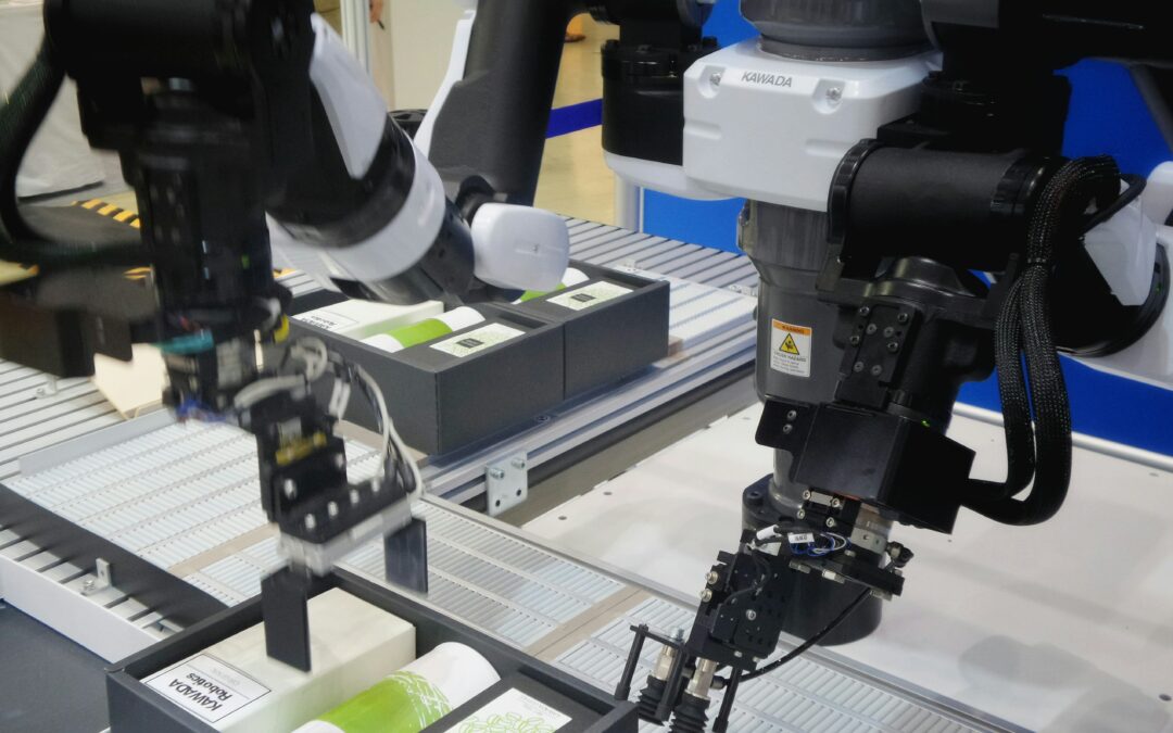 Ein Robotersystem mit zwei Gelenkarmen legt Produkte in Kartons an einem Fließband. Die Szene zeigt die industrielle Digitalisierung und zeigt im Rahmen von jobs der Zukunft die Automatisierung von Verpackungsprozessen. Die Roboter handhaben verschiedene Artikel mit Präzision.